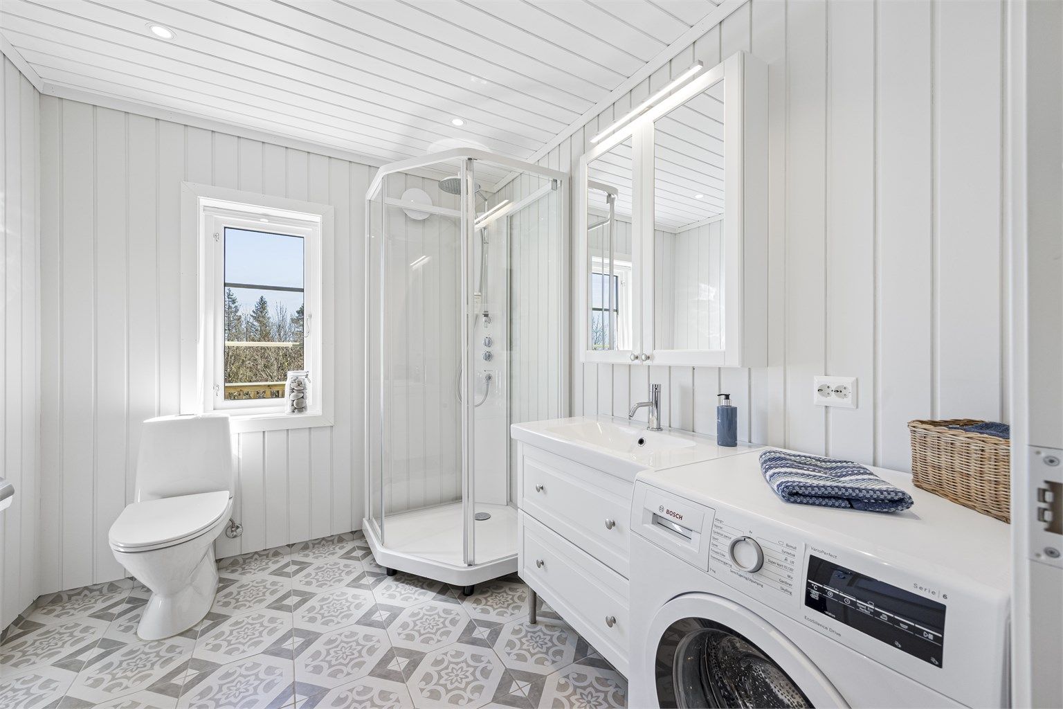 Bad og vaskerom fra 2021 i tilbygget. Rommet har flislagt gulv med gulvvarme, dusjkabinett og opplegg for vaskemaskin. Vaskemaskin følger med.