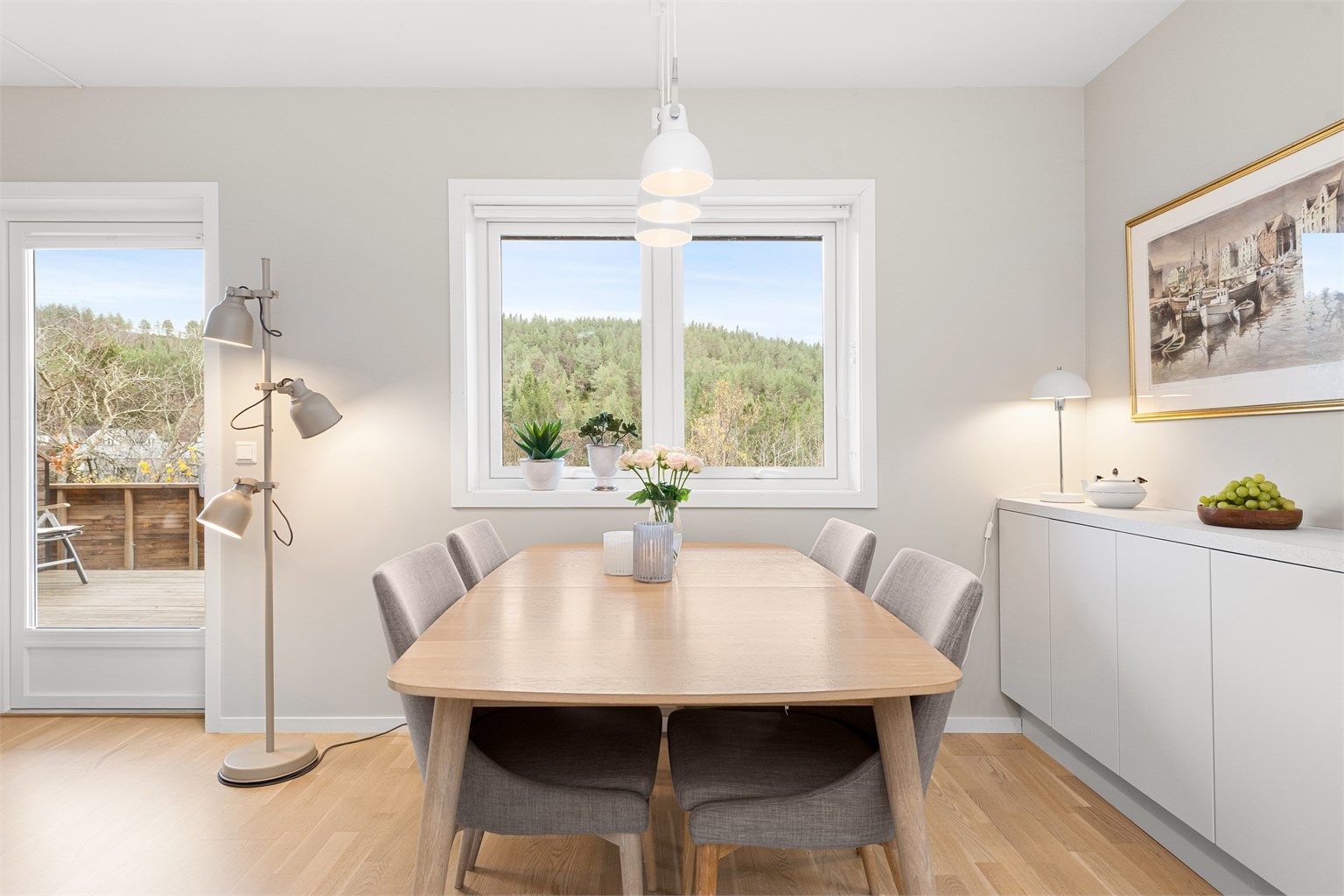 Spiseplass på kjøkken plassert ved vindu med utsikt mot terrasse og hage