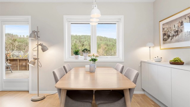 Spiseplass på kjøkken plassert ved vindu med utsikt mot terrasse og hage