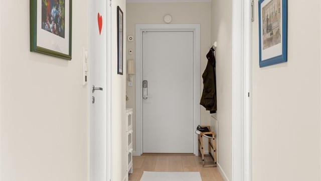 Entréen har downlights i taket og entrédør med kodelås.