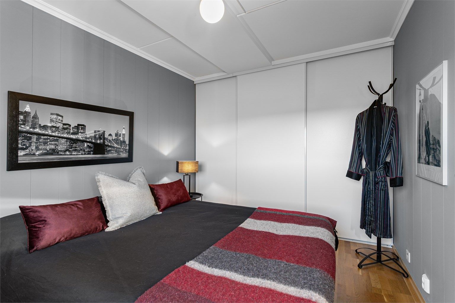 Hovedsoverommet har en plassbygget skyvedørsgarderobe i hvit og glatt utførelse.