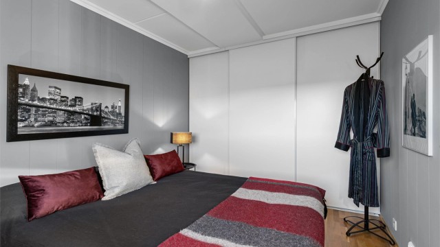 Hovedsoverommet har en plassbygget skyvedørsgarderobe i hvit og glatt utførelse.