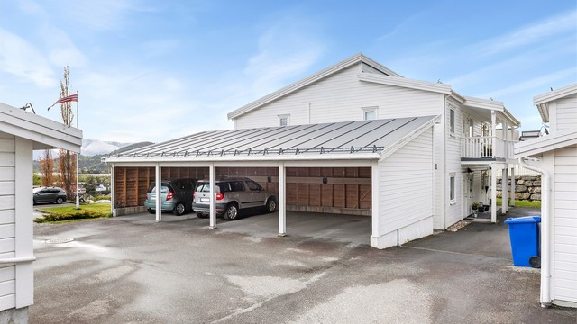 Egen parkeringsplass i carport. Plassen er utstyrt med elbillader.