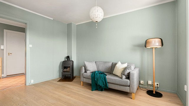 I det ene hjørnet er det montert en peisovn som gir god varme til leiligheten