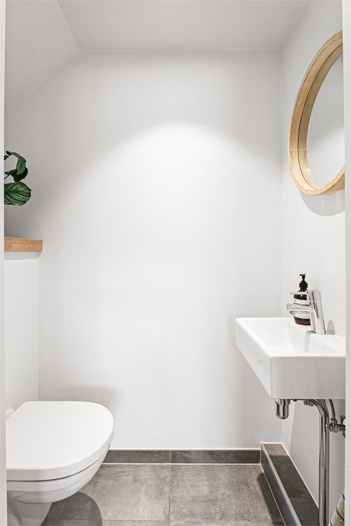 Gjestetoalett med gulvfliser med gulvvarme og malte veggflater, samt downlights i himling