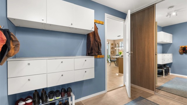 Entréen har et praktisk flislagt gulv med gulvvarme og rikelig med oppbevaringsplass.