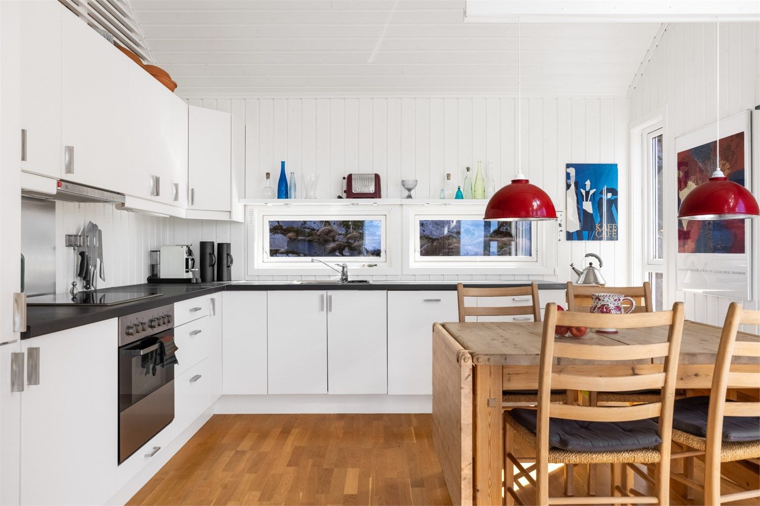 Pent kjøkken med lyse slette flater og benkeplate i kontrast. 