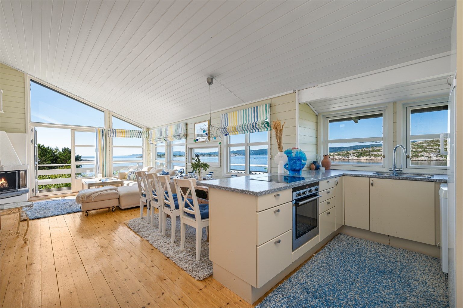 Kjøkkenet ligger naturlig skjermet fra stuen og er innredet lyse slette fronter og benkeplate i kontrast. 