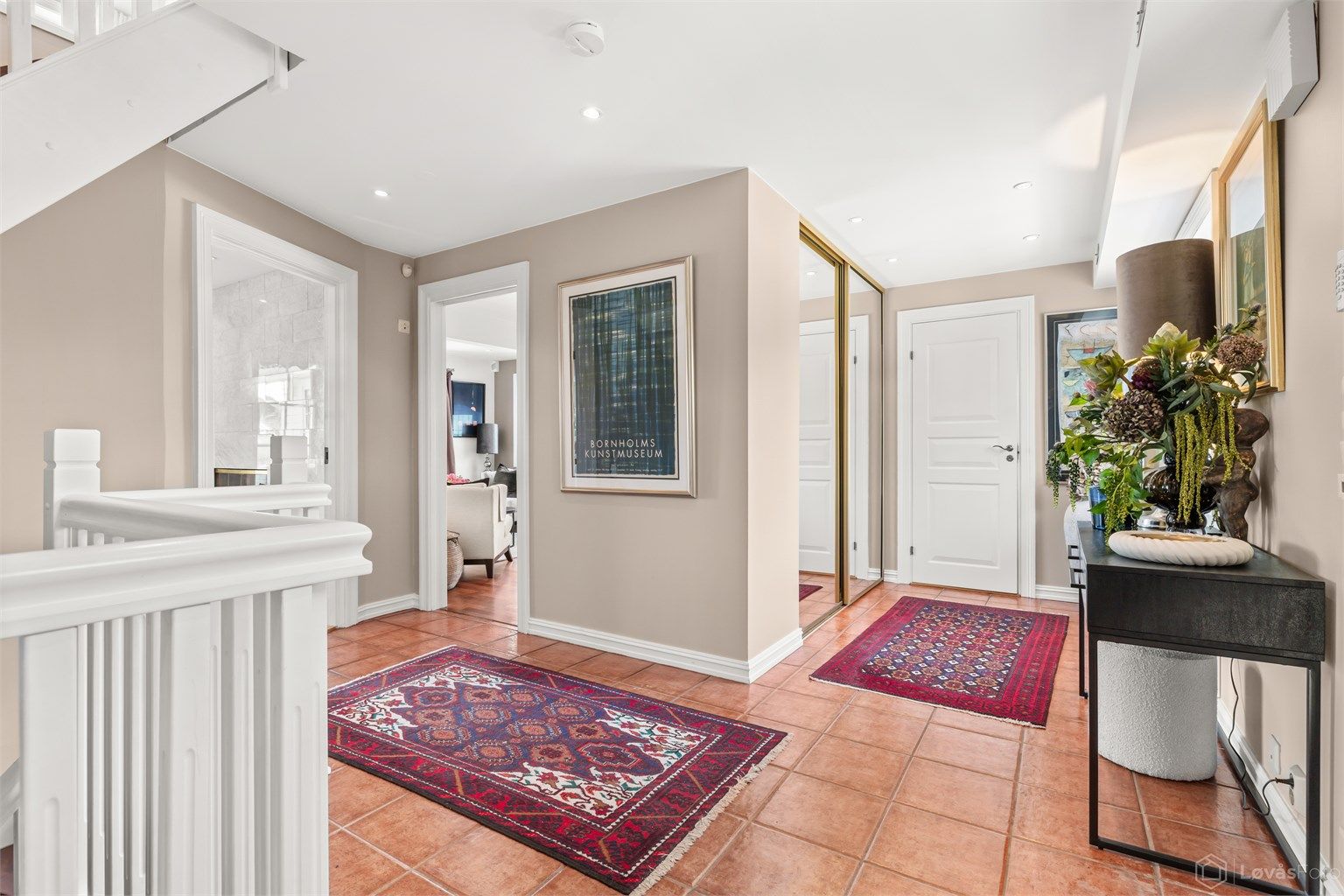 Romslig entré/hall med gulvfliser med gulvvarme og skyvedørsgarderobe med god plass til yttertøy