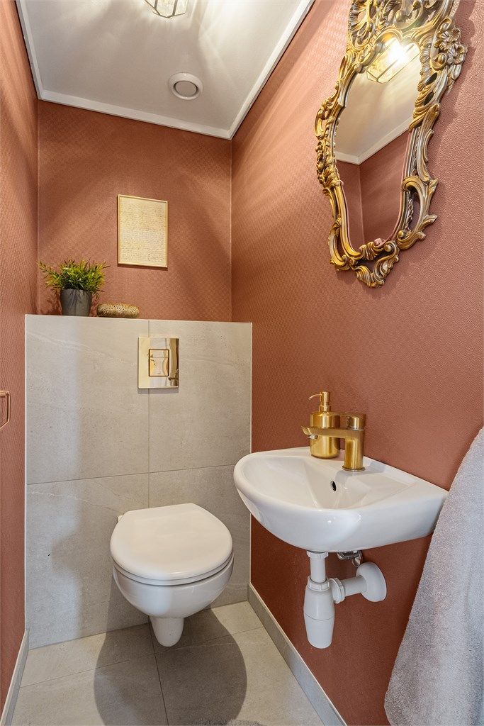 Wc med fliser på gulv, malte vegger og enkel servant. Praktisk gjestewc i tillegg til at det er toalett på bad. 