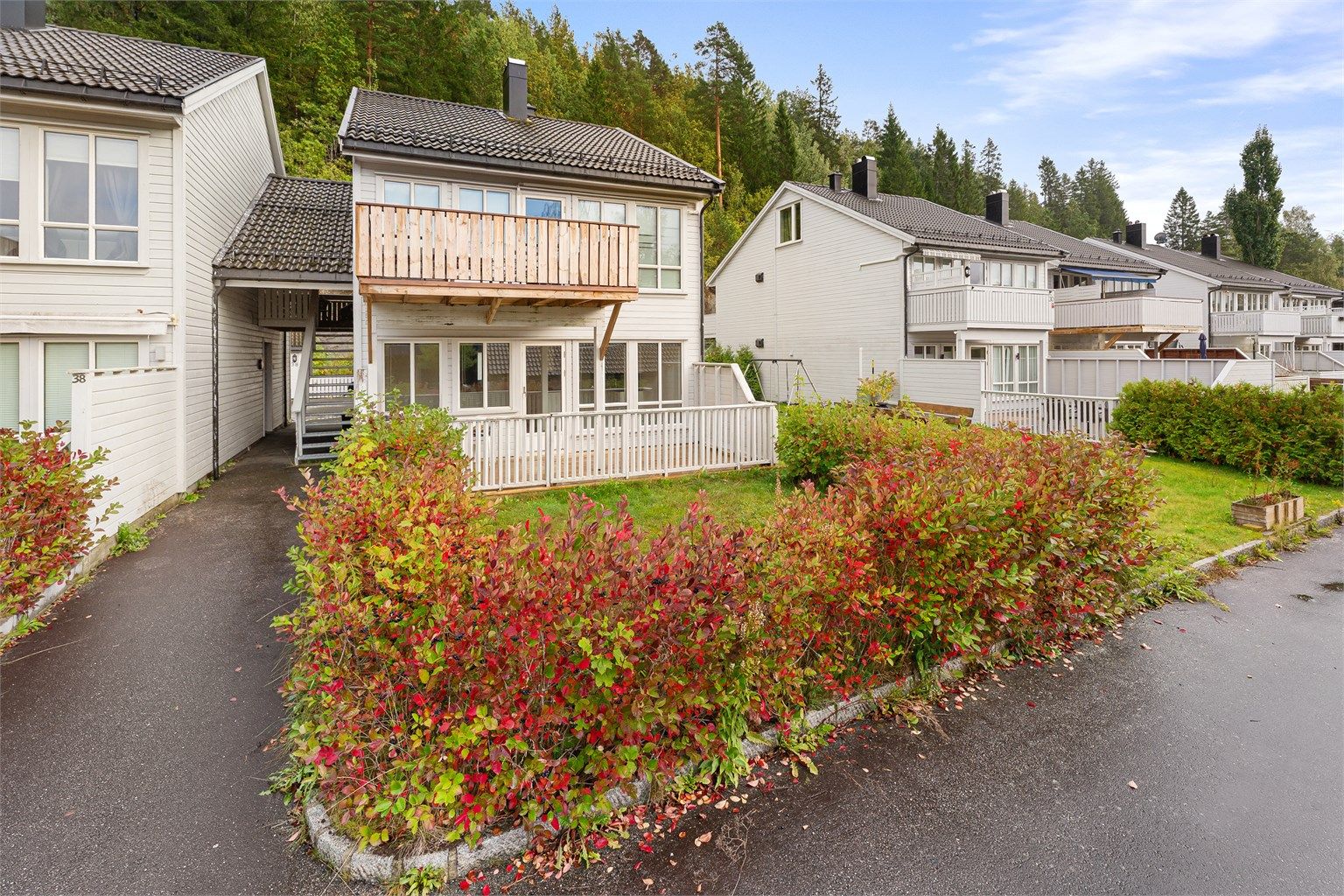 Boligen har et hyggelig inngangsparti med beplantning og fine utearealer.