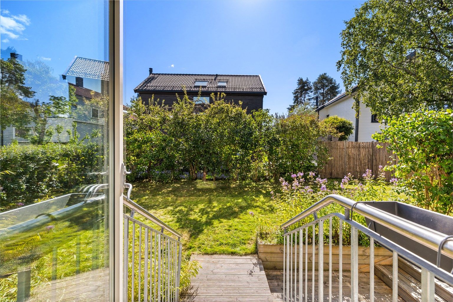 Fra stuen ser man rett ut i den grønne hagen.