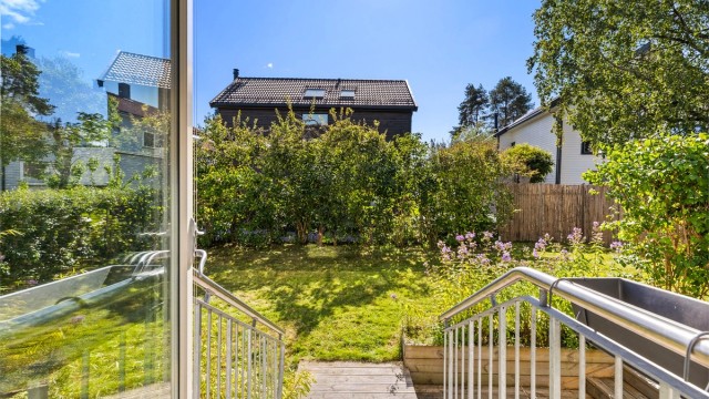 Fra stuen ser man rett ut i den grønne hagen.