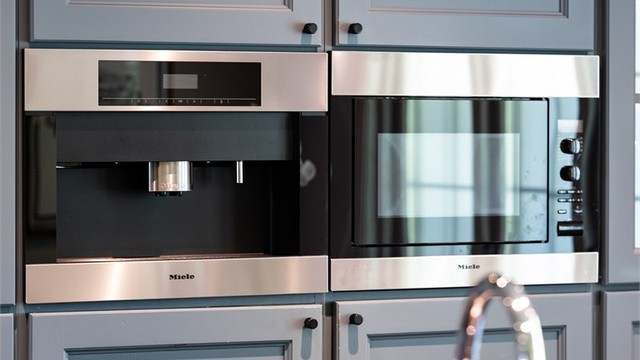 Kaffemaskin og mikrobølgeovn fra Miele er integrert i høyskapet.