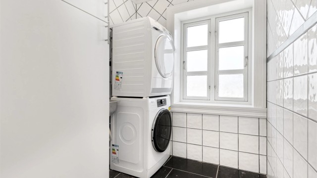 Vaskerom med opplegg for vaskemaskin og tørketrommel. Skap og kum.