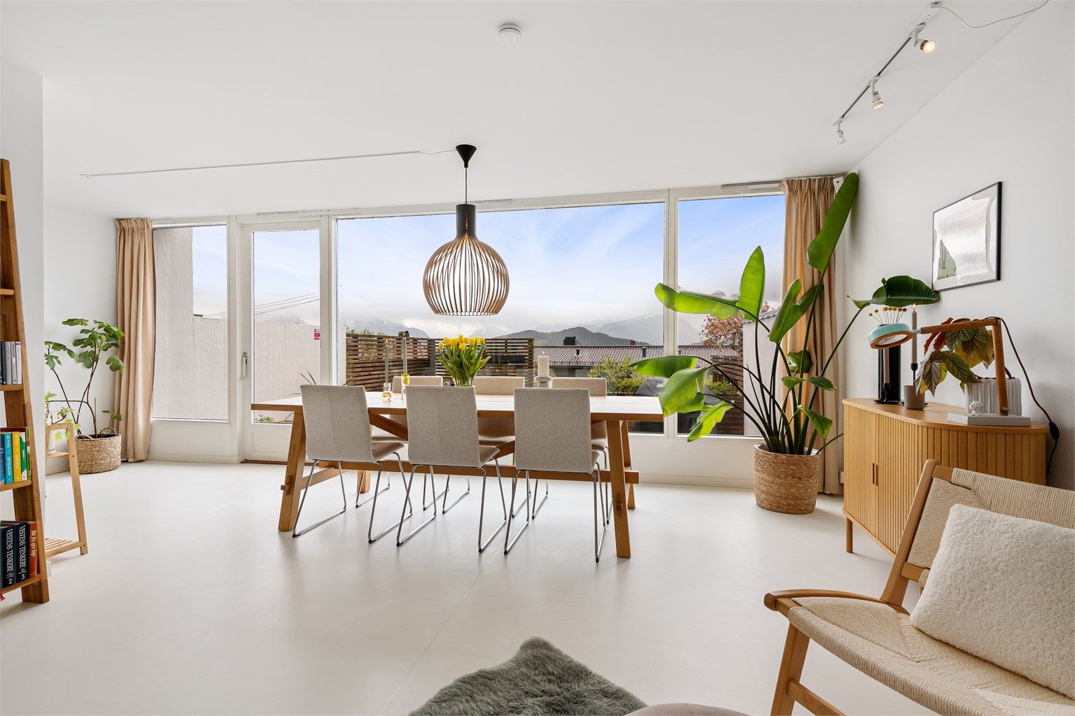 Stue/spisestue med lyse overflater og godt med naturlig lysinnslipp fra store vinduer