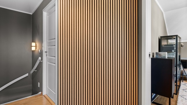 Moderne akustikkpanel i trapperommet gir en stilren overgang til andre etasje.