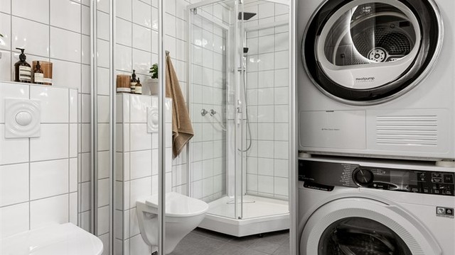 Praktisk vaskeromsnisje med opplegg for vaskemaskin og tørketrommel, skjult bak speilskyvedører.