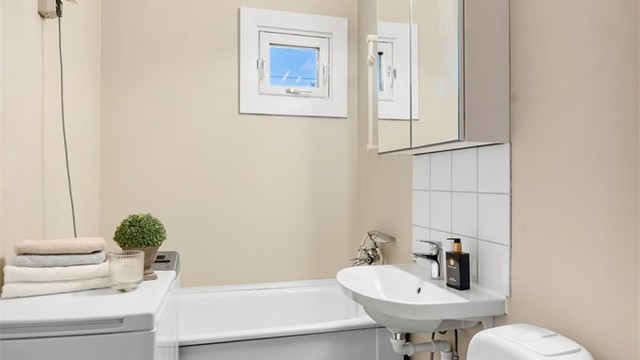 Badet er utstyrt med badekar og har vindu som gir naturlig ventilasjon.