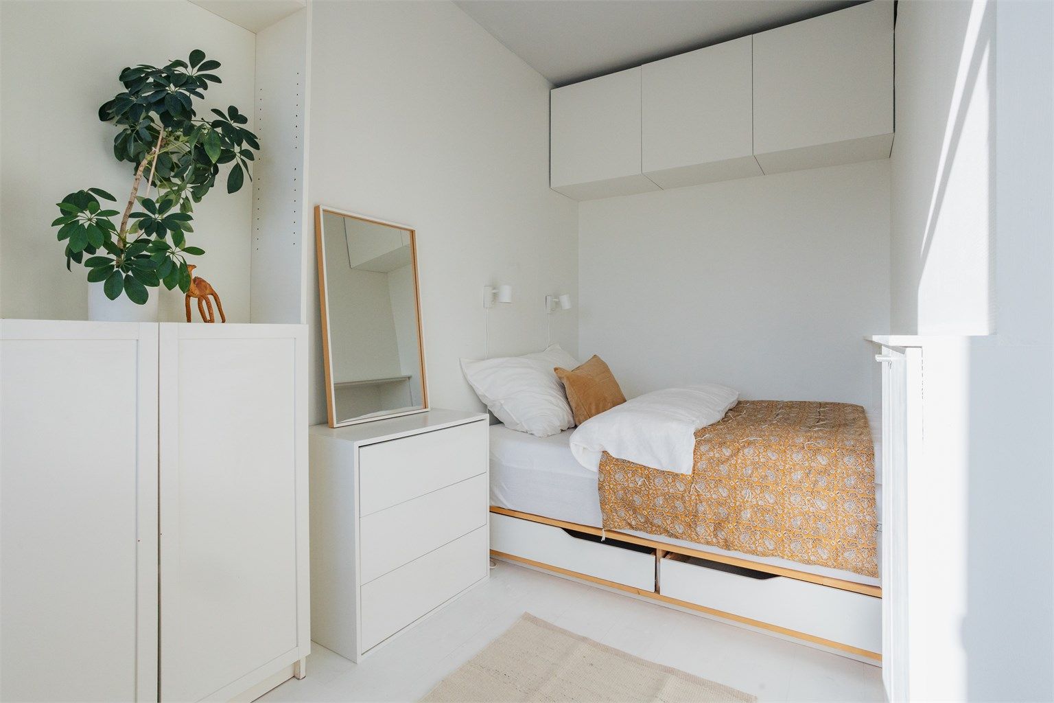 Lyst og delikat soverom med plassbygget seng og gode oppbevaringsmuligheter