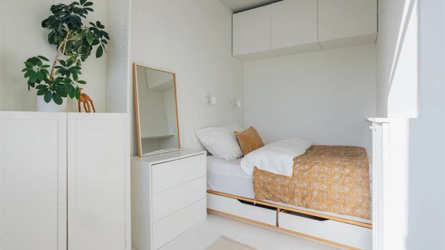 Lyst og delikat soverom med plassbygget seng og gode oppbevaringsmuligheter