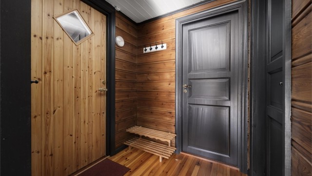 Entréen har furupanel på veggene, tregulv og plass til klesoppheng.