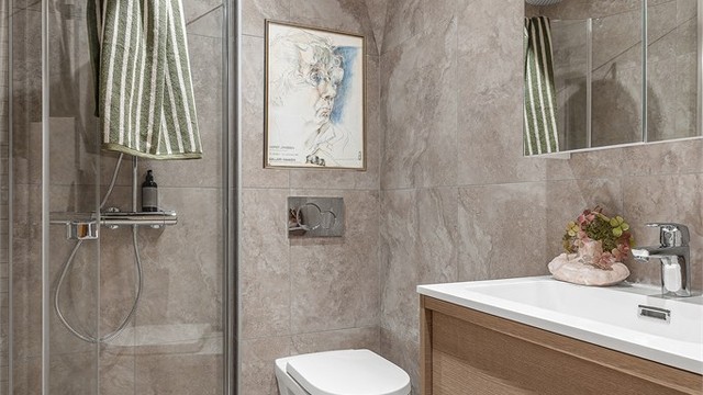 Badet i underetasjen er fra 2026 og er utstyrt med enkelservant med ett-greps armatur, speil og servantskap. Badet har også dusj med svingbare dører og vegghengt toalett.
