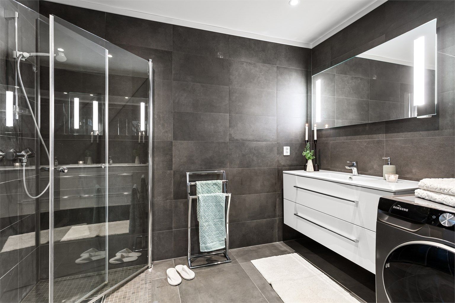 Pent flislagt bad med gulvvarme. Himling med downlights. Dusjhjørne med nedsenket gulv med dører i glass.