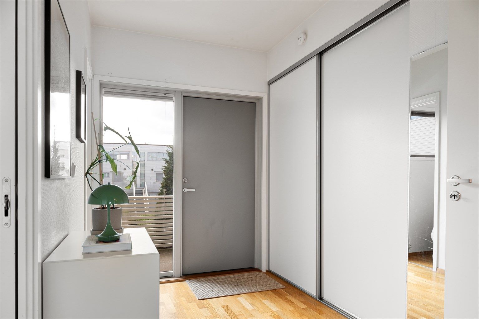 Gangen er innredet med en stor skyvedørsgarderobe. 