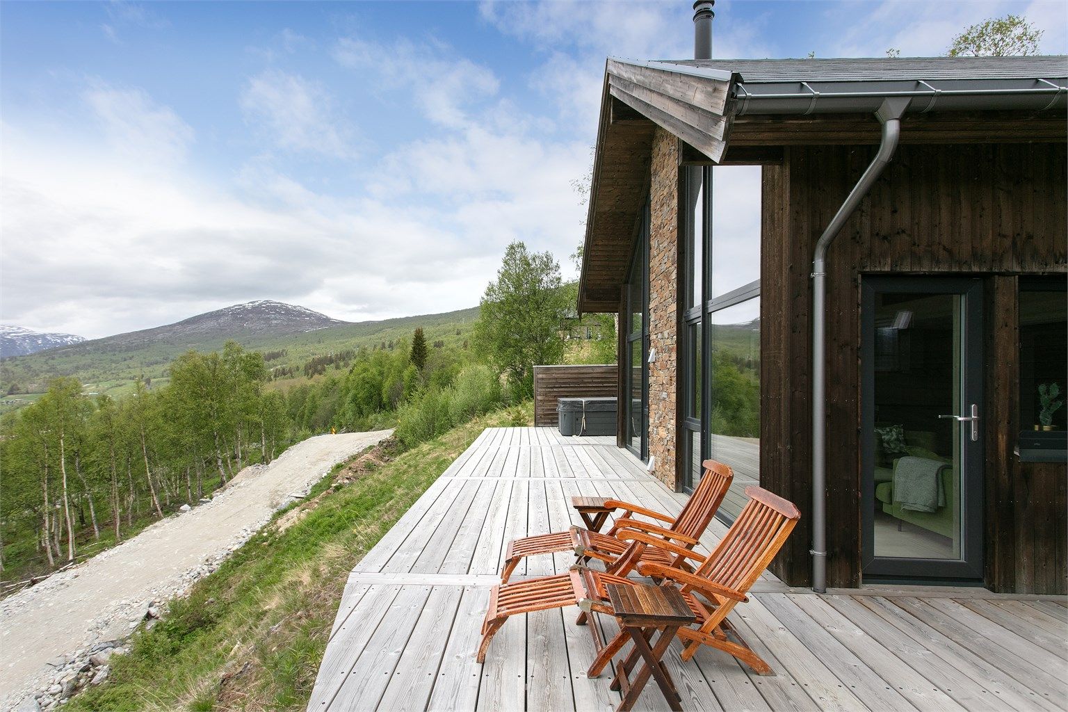Terrassebord i tre og fasadedetaljer med naturstein harmonerer godt med fjellandskapet.