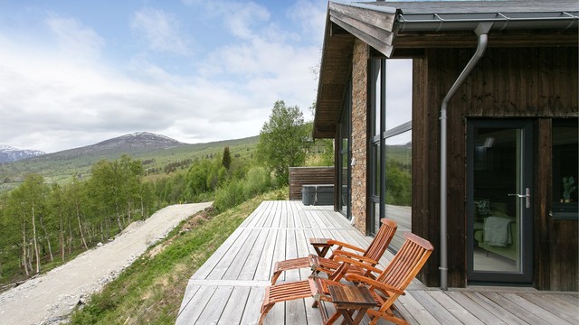 Terrassebord i tre og fasadedetaljer med naturstein harmonerer godt med fjellandskapet.