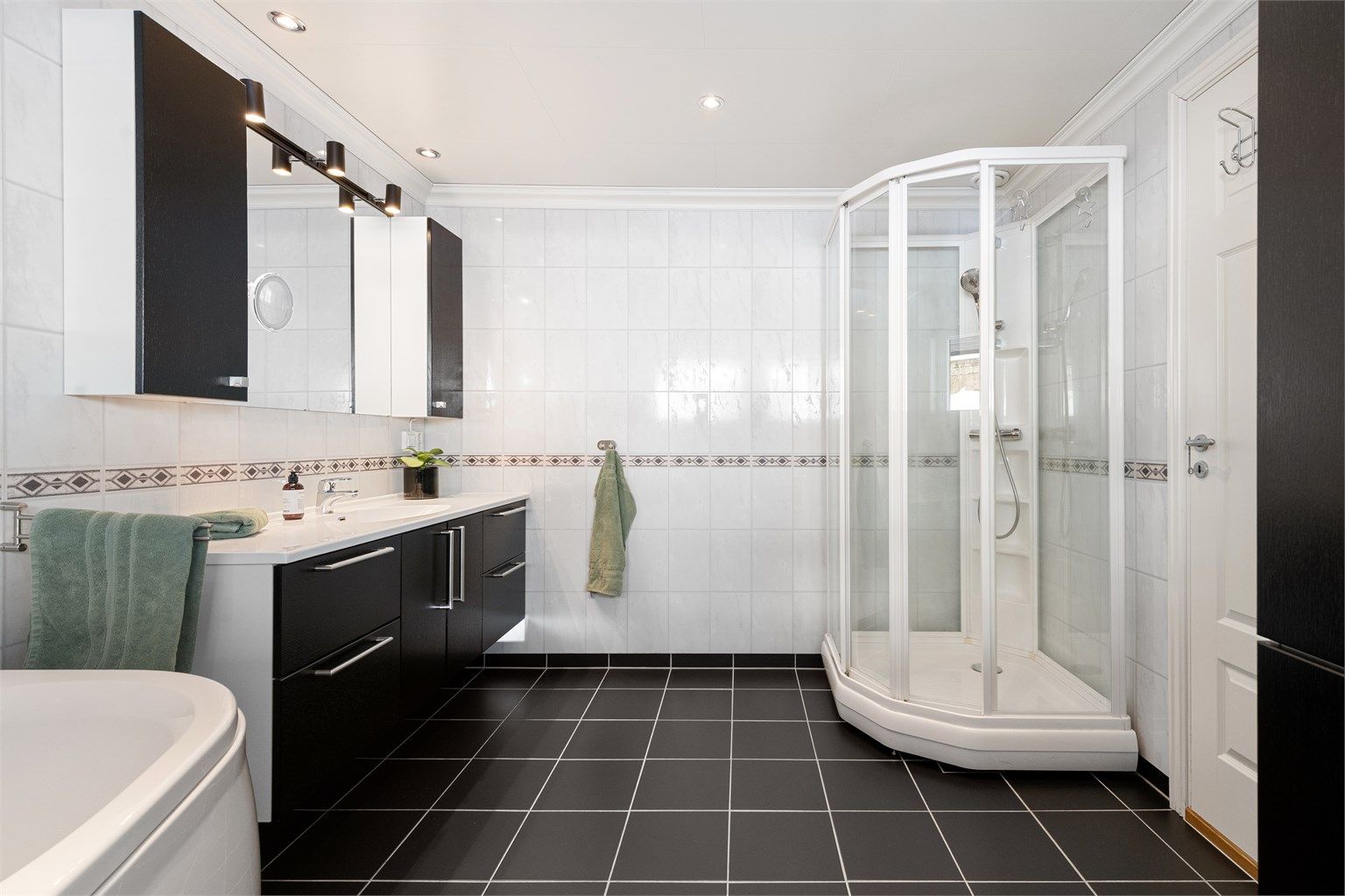 Bad med tilkomst via hovedsoverom. Badet er fra 2009 og har flislagt gulv, baderomsplater på vegger og takplater i tak. 