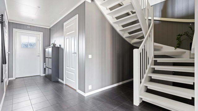 Velkommen inn i en romslig entré med flislagt gulv og behagelig gulvvarme.