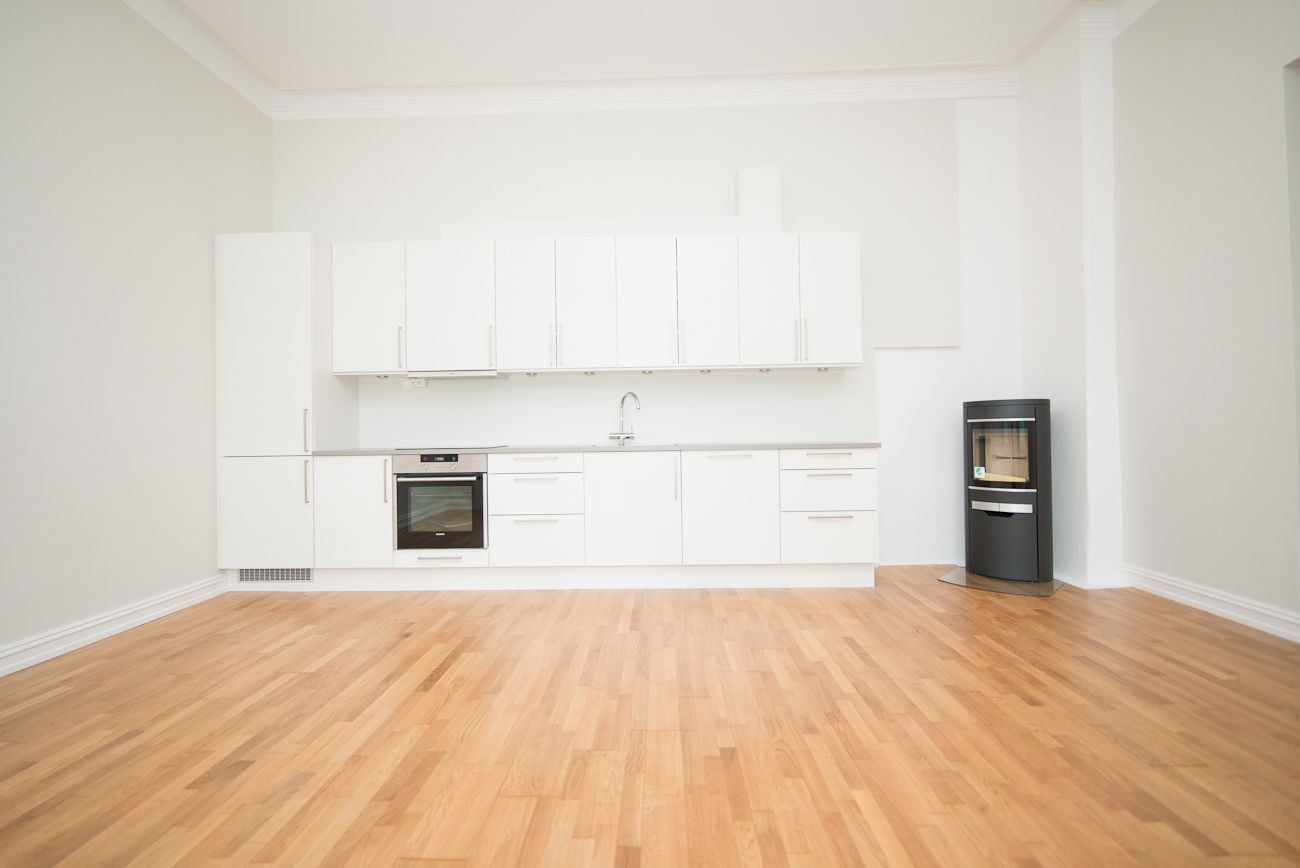 Stue med åpen kjøkkenløsning m/peis og utgang til balkong.