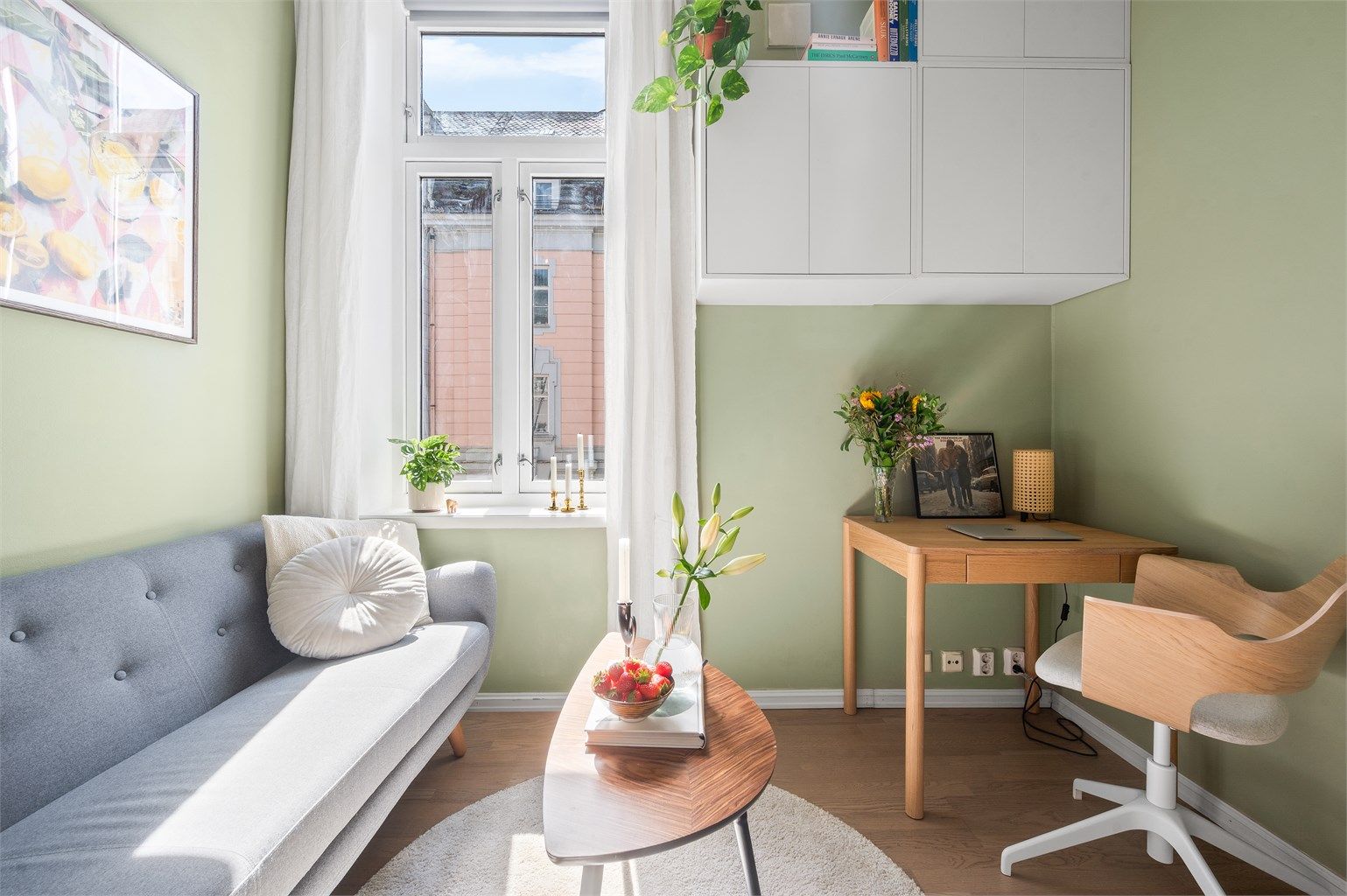 Stuen er hold i moderne og tidsriktige nyanser som sammen med en stor vindusflate skaper en god atmosfære i leiligheten.