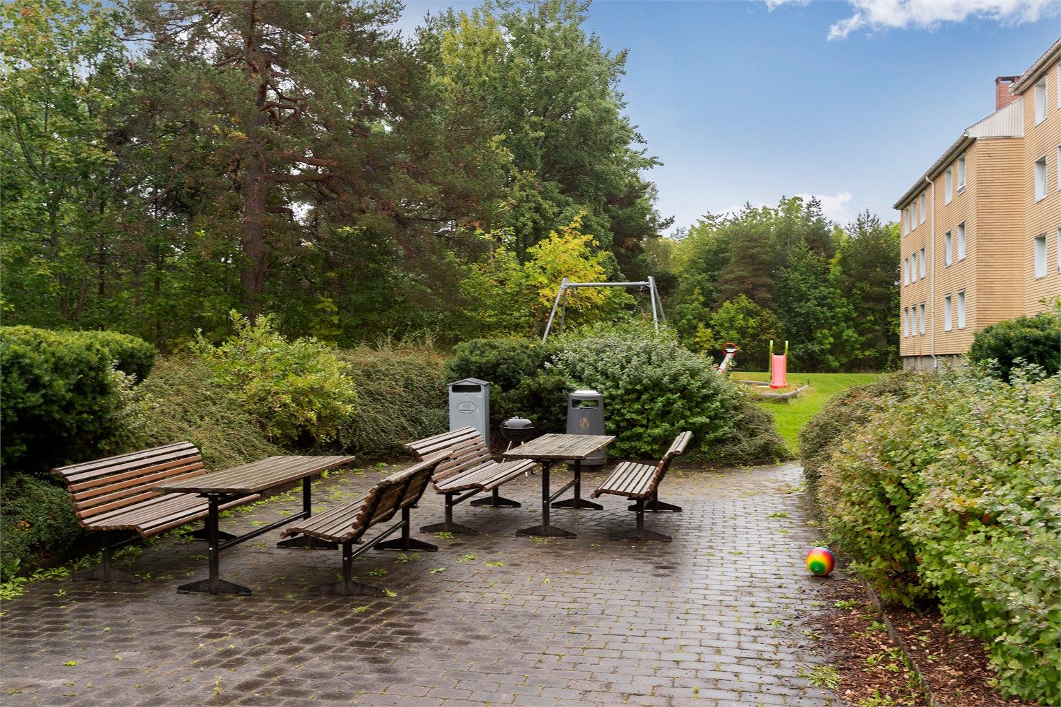 Felles sitteplass med bord og benker til bruk for borettslagets beboere.