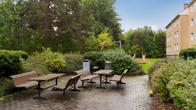 Felles sitteplass med bord og benker til bruk for borettslagets beboere.