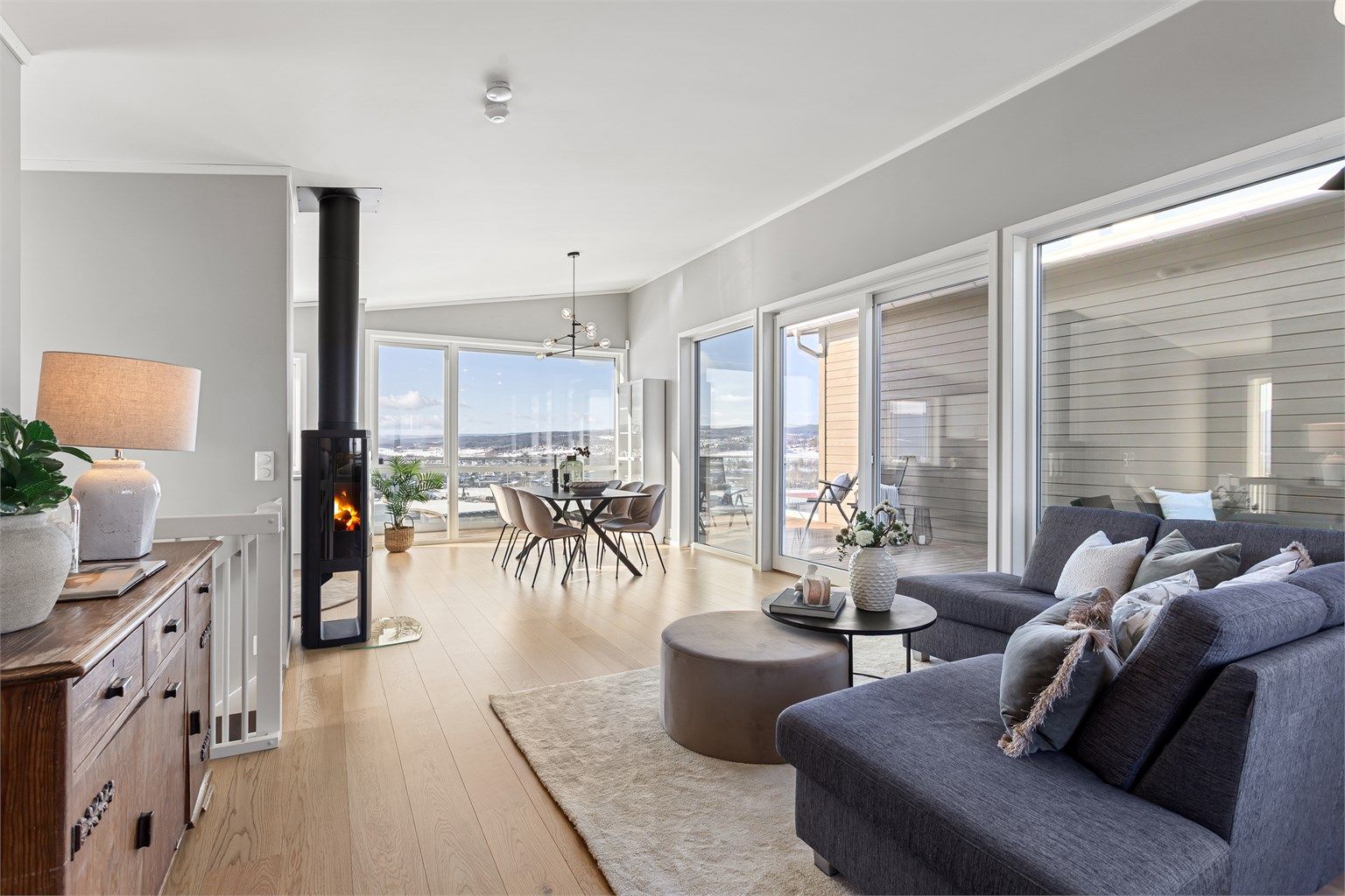 Stue med plass til sofagruppe og spisebord. Utgang fra stuen til flott uteplass på veranda