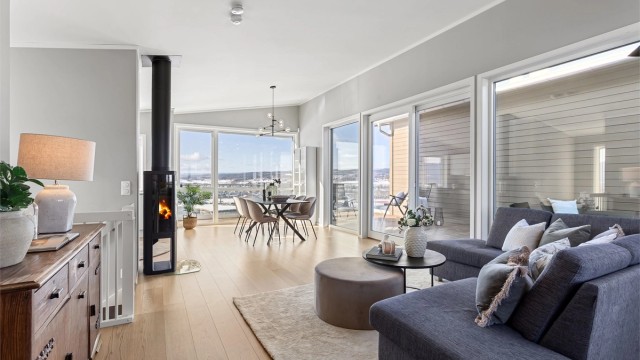 Stue med plass til sofagruppe og spisebord. Utgang fra stuen til flott uteplass på veranda