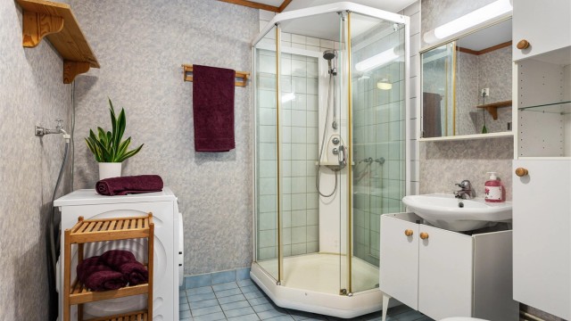 Badet har flislagt gulv med gulvvarme og det er praktisk opplegg for vaskemaskin.