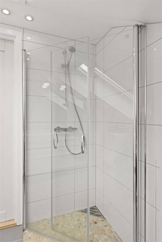 Dusjhjørnet har innfellbare glassdører som frigjør gulvplass når dusjen ikke er i bruk.