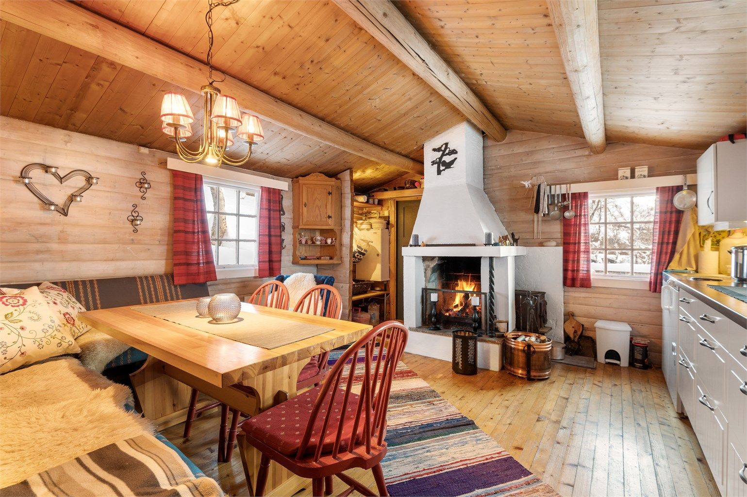 Hytta har stue/kjøkken i første etasje, og en stor og hyggelig peis som blikkfang. 