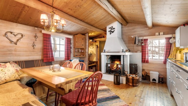 Hytta har stue/kjøkken i første etasje, og en stor og hyggelig peis som blikkfang.