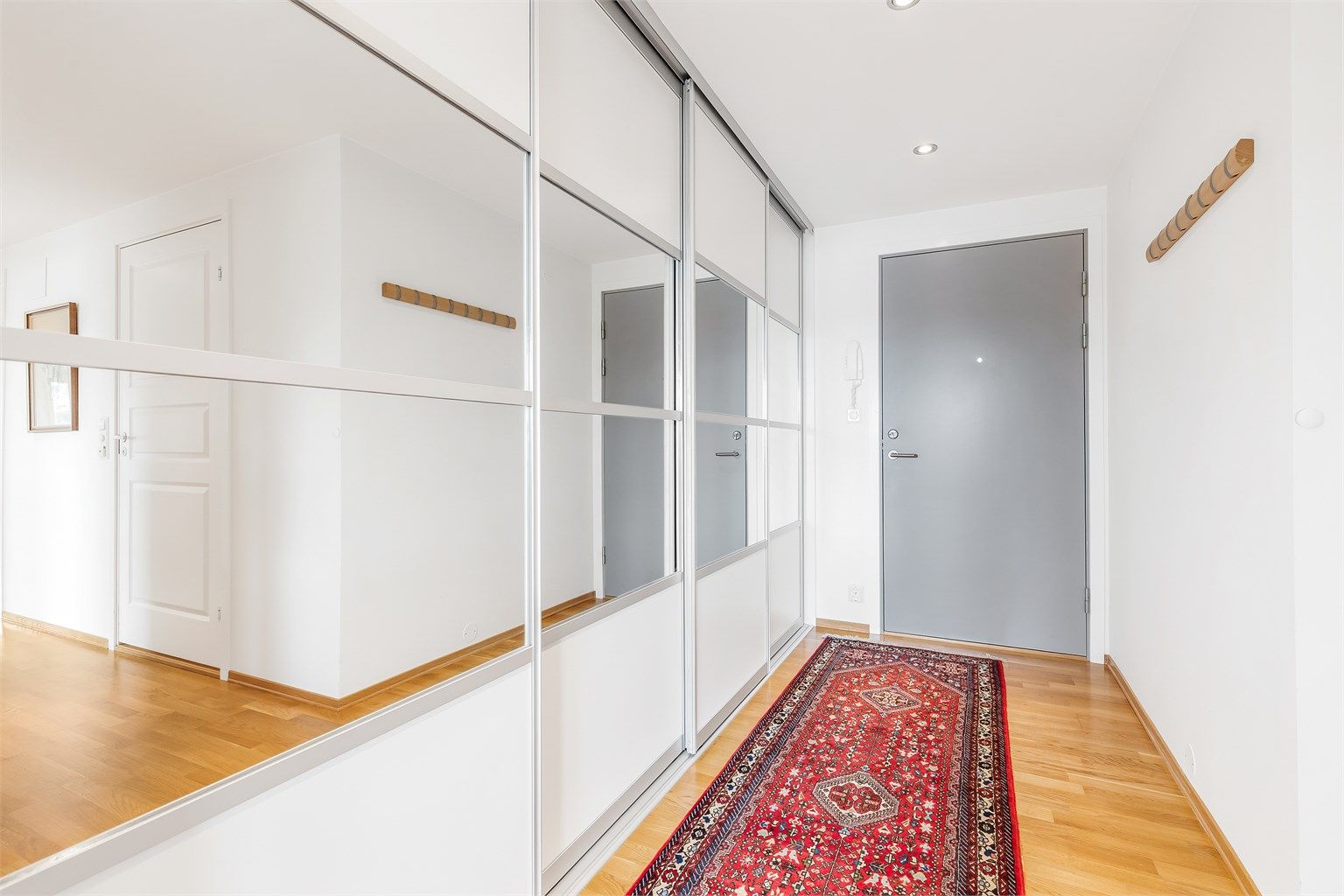 Romslig entré med stor integrert skyvedørsgarderobe.
