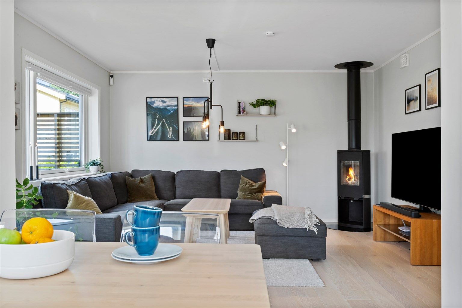 En moderne peisovn med glassdør gir ekstra varme og hygge i stuen.