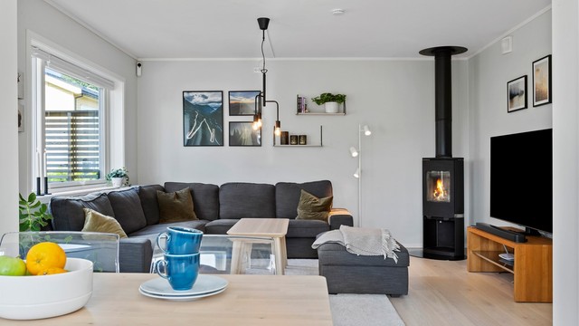 En moderne peisovn med glassdør gir ekstra varme og hygge i stuen.
