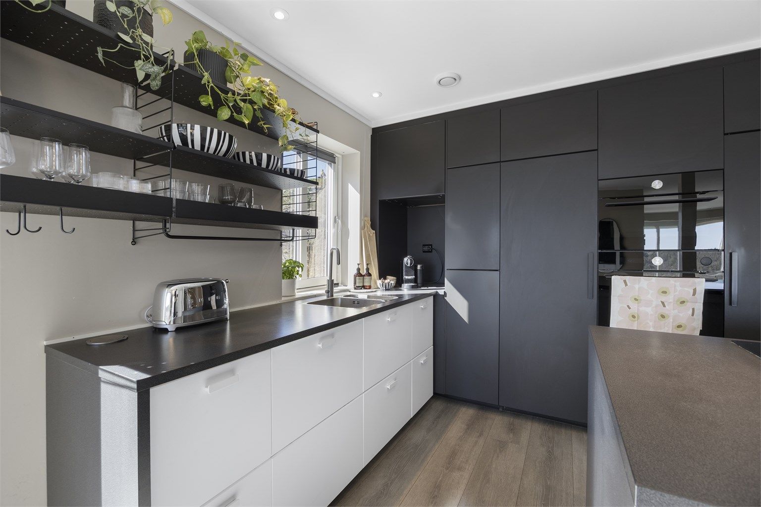 Innredningen har glatte fronter og integrerte hvitevarer som stekeovn, mikrobølgeovn, oppvaskmaskin og kjøleskap.