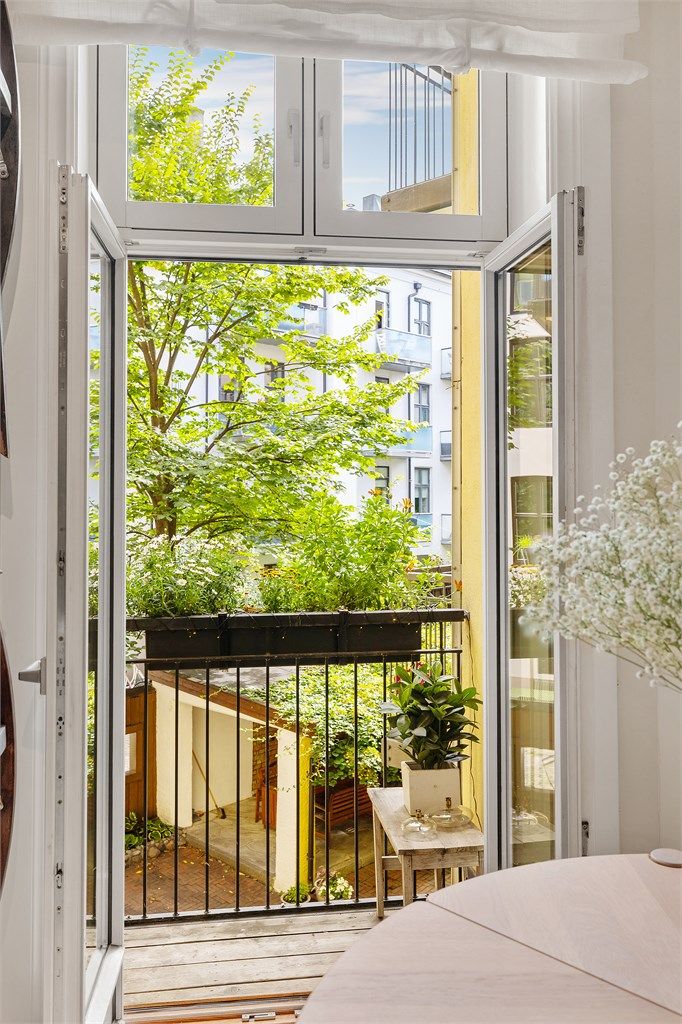 Sjarmerende sydøstvendt balkong vendt ut mot en grønn og rolig bakgård.