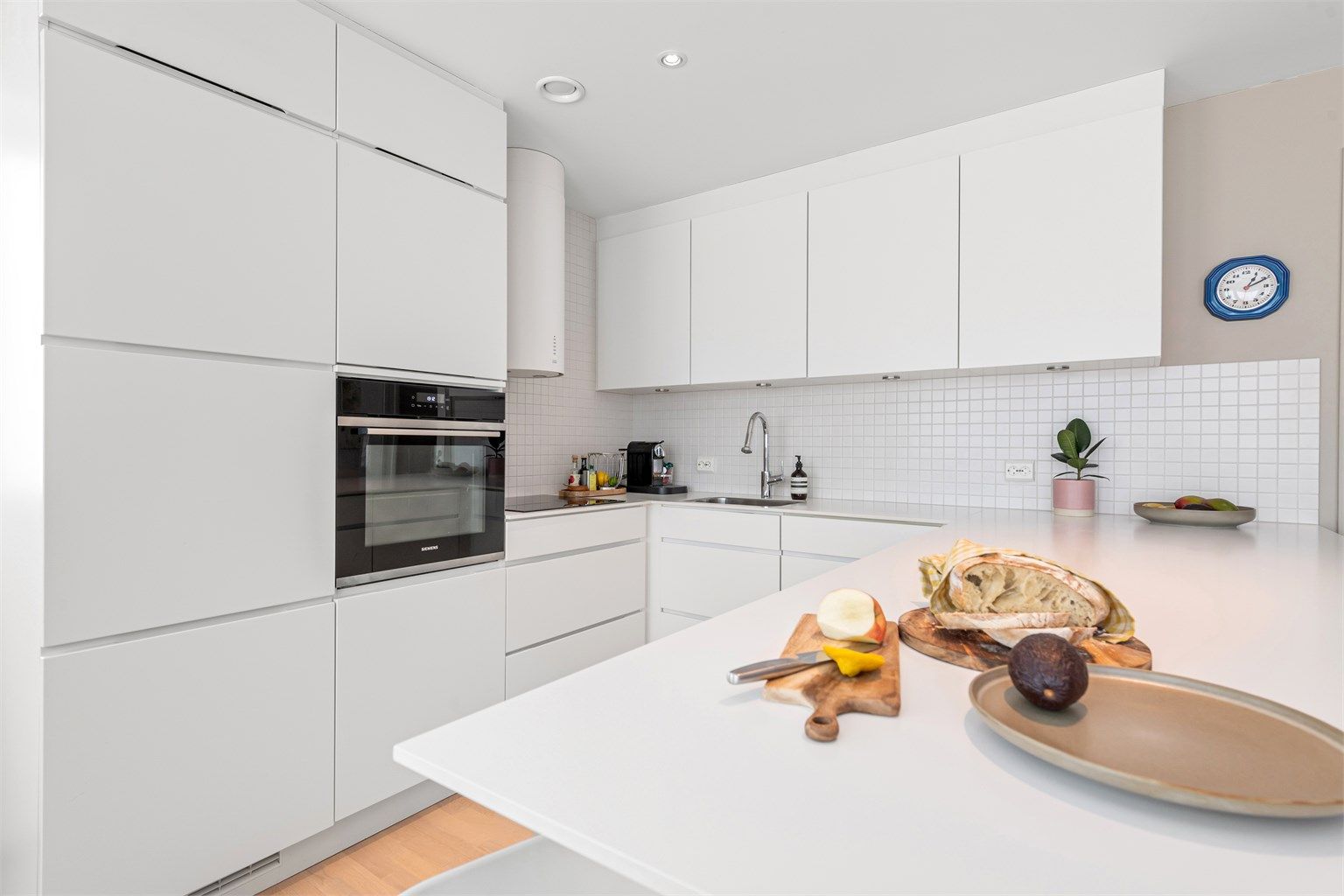 Benkeplaten er i laminat med nedfelt oppvaskkum, og det er fliser over benken.