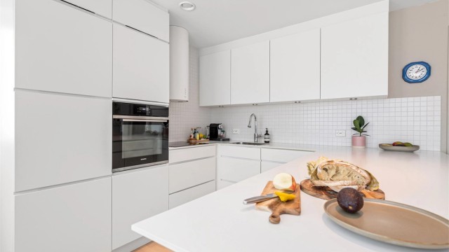 Benkeplaten er i laminat med nedfelt oppvaskkum, og det er fliser over benken.